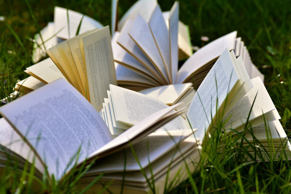 Home An artistic arrangement of open books in a grassy field, emphasizing a love for outdoor reading.